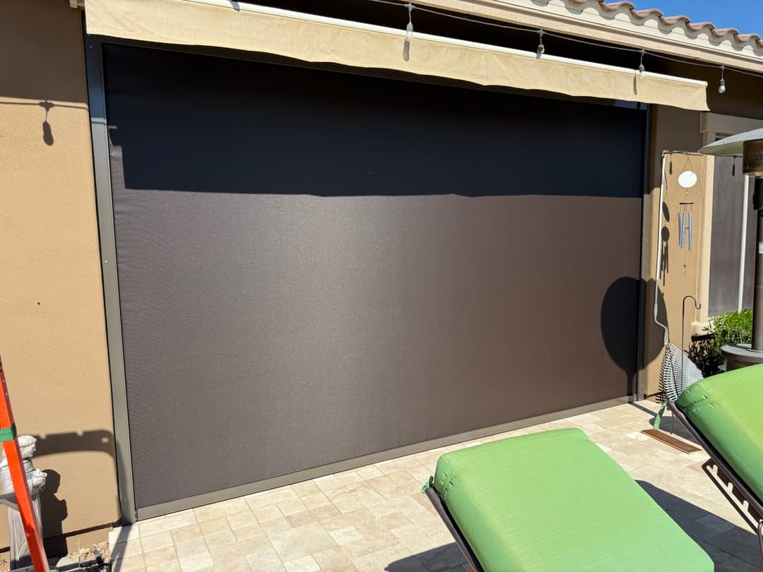 Black retained patio shade lowered on a Phoenix pool patio