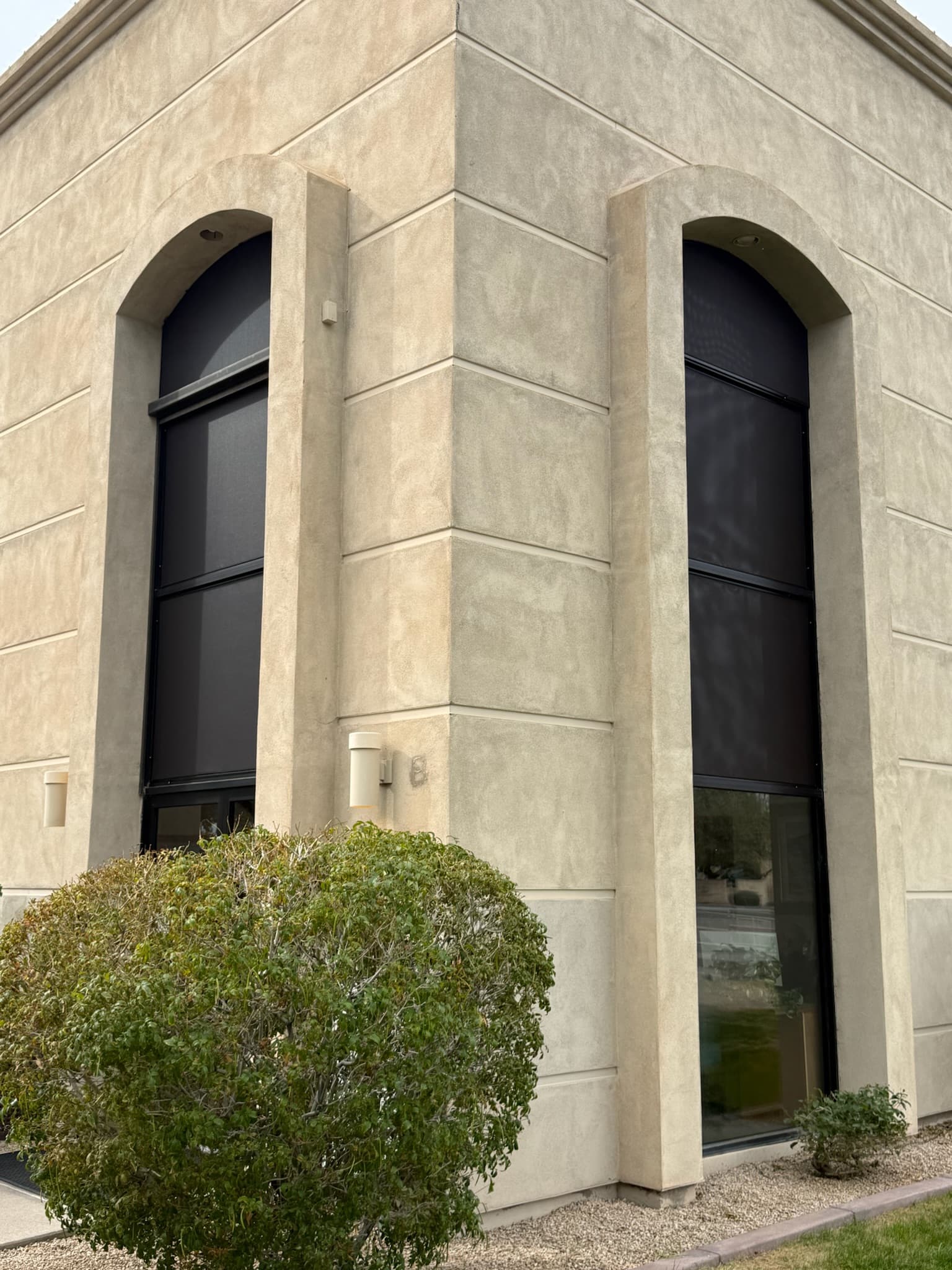 Dark exterior shades installed on tall Phoenix commercial windows