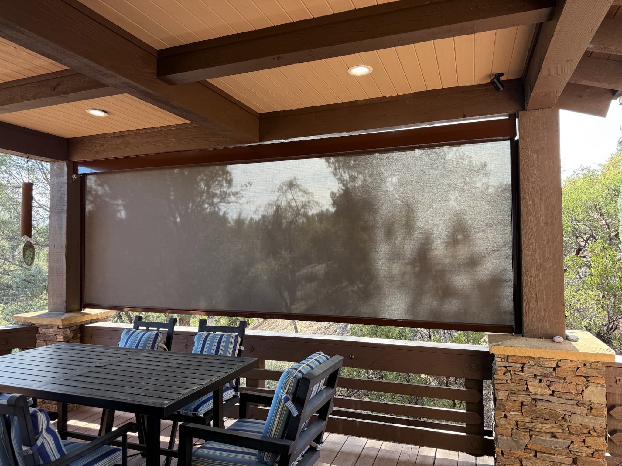 Custom patio screen shade lowered on a Phoenix covered deck
