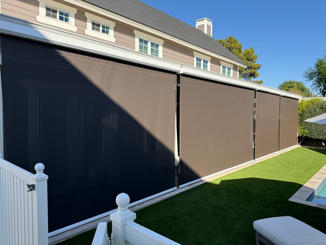 A luxurious backyard in Phoenix AZ, with three large Phantom Screens / Drop Shades protecting their patio,