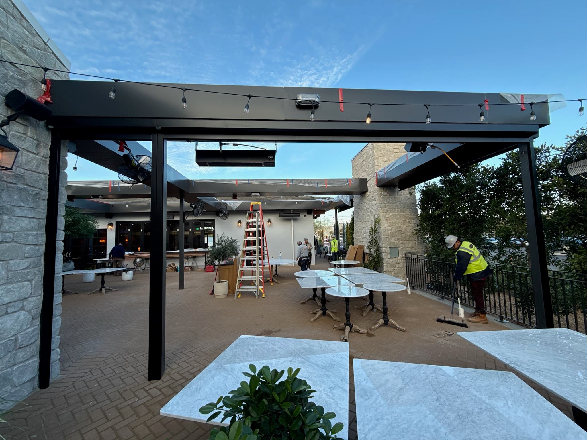 Large motorized exterior screens for covered outdoor shade