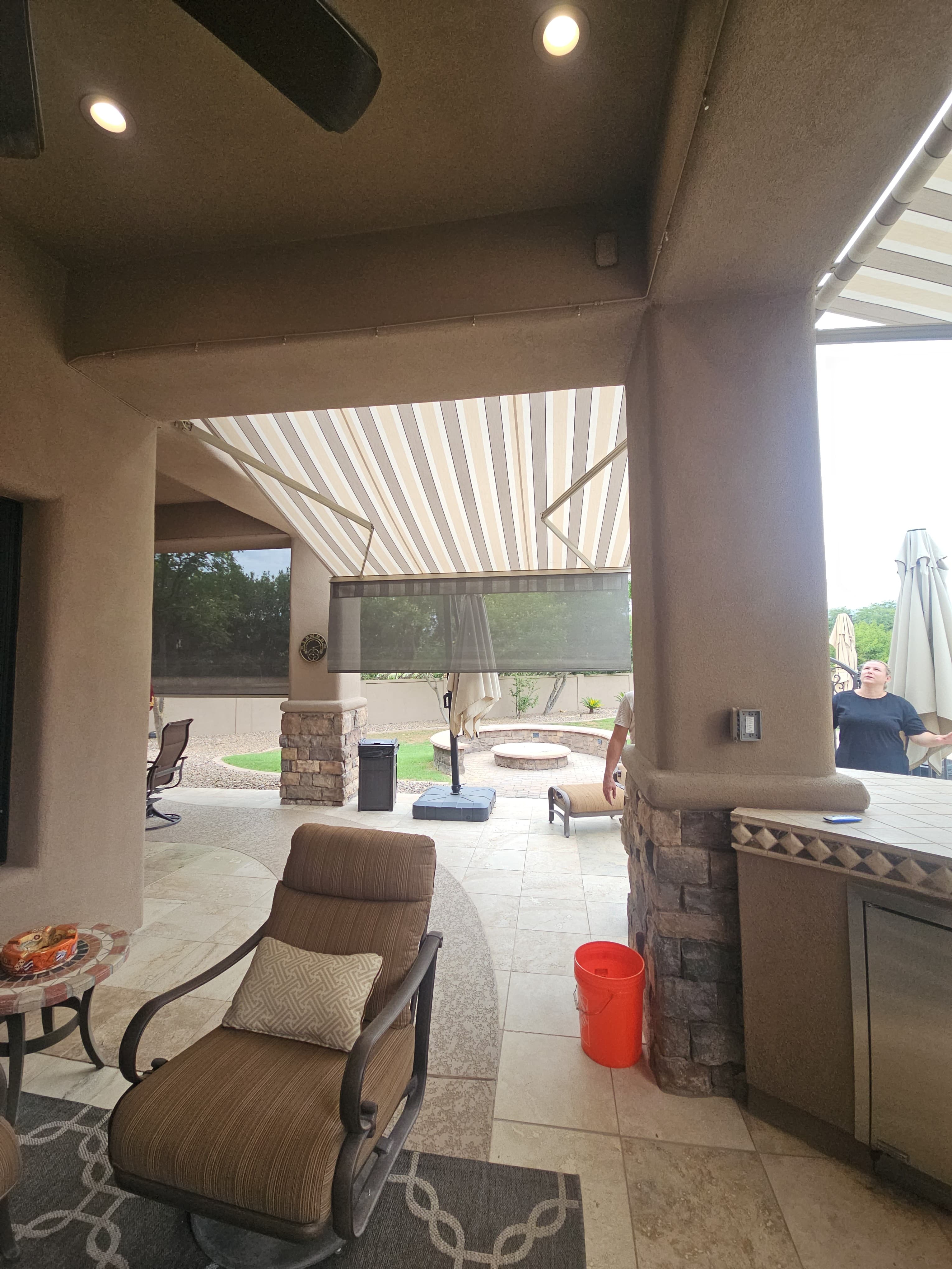 Restored striped awnings shading a covered outdoor living area