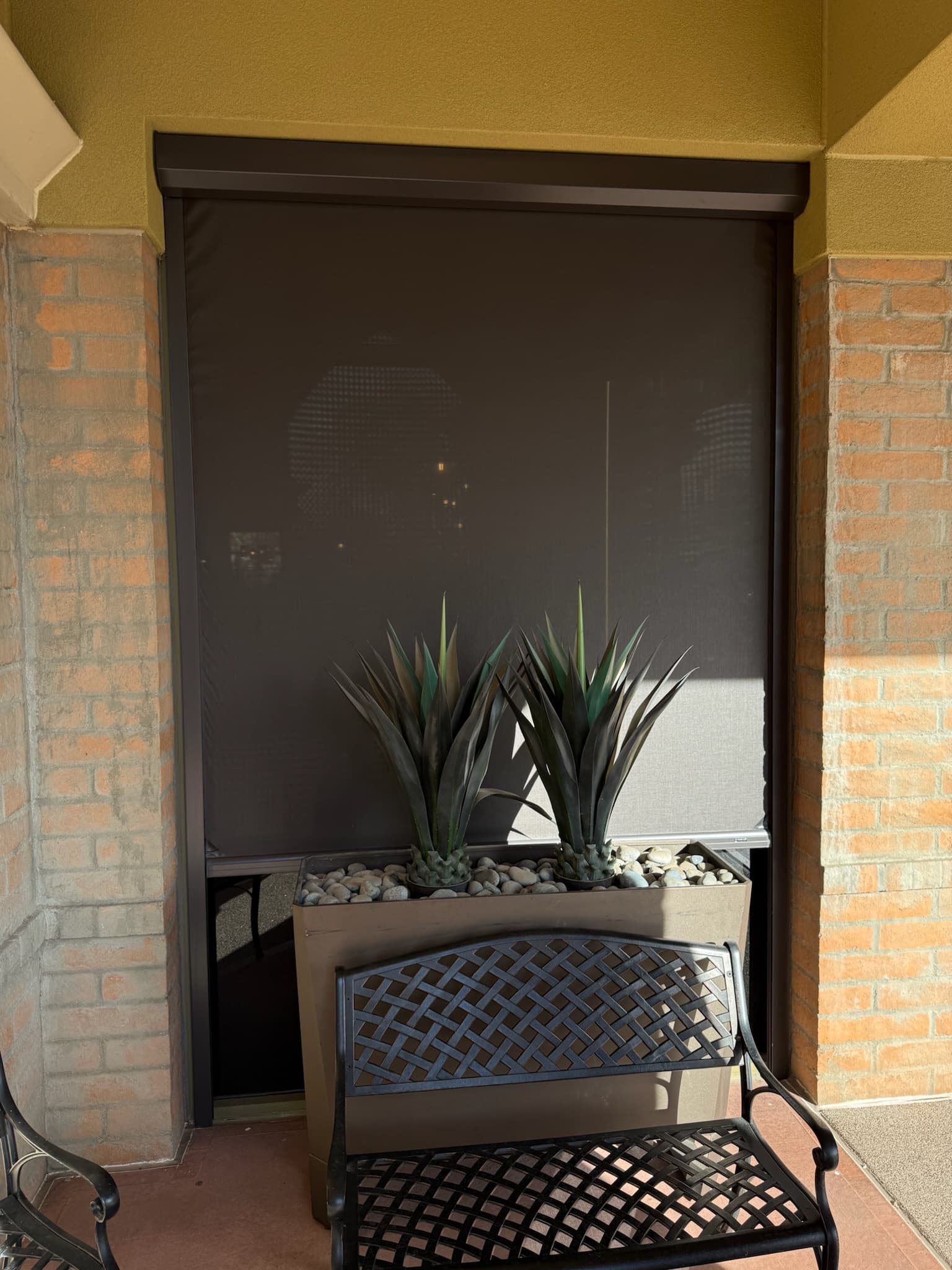 Exterior roll shades installed across a commercial patio opening