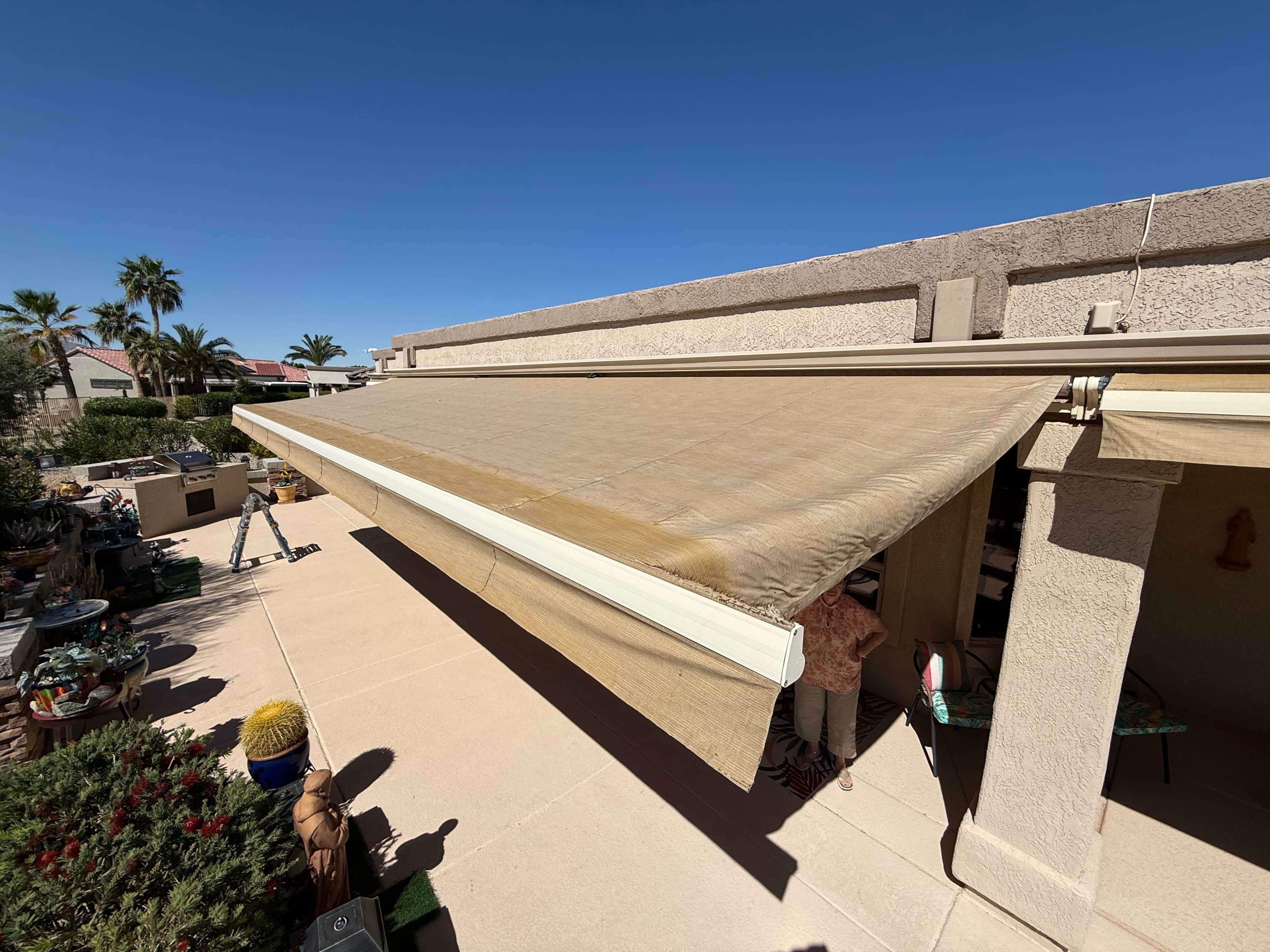Worn and sun-faded tan awning fabric before recovery