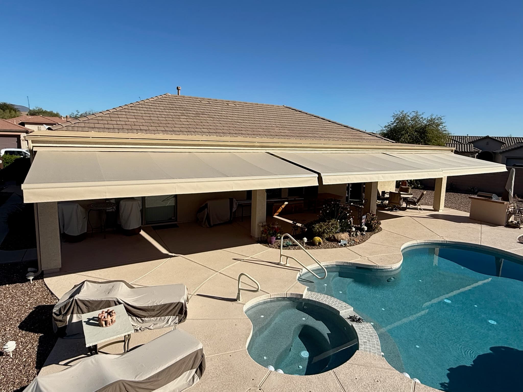 Three large tan awnings providing broad shade coverage